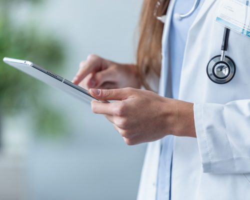 Close-up of female doctor using her digital tablet in the office.